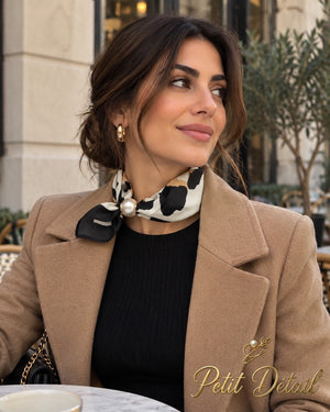 Woman wearing black ivory and camel animal print magnetic scarf with pearl closure