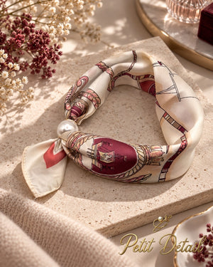 Ivory and burgundy equestrian magnetic scarf with pearl magnetic closure styled in a warm neutral setting
