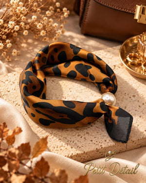 Caramel and black leopard print magnetic scarf with pearl magnetic closure styled in a warm neutral setting