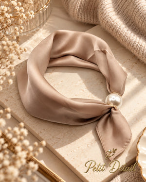 Champagne beige magnetic scarf with pearl magnetic closure styled in a soft neutral setting