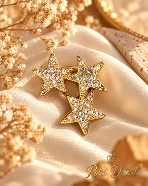 Gold-tone crystal star trio brooch styled on satin fabric