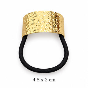 Gold-tone hair cuff with embossed circular bubble pattern and attached black elastic on white background, 4.5 x 2 cm