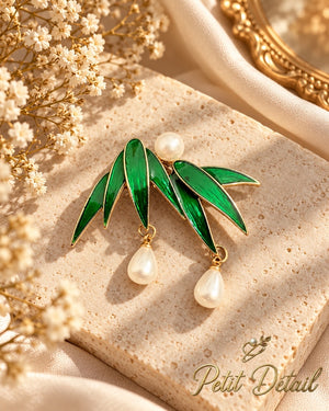 Emerald green pearl leaf brooch styled on a warm neutral background
