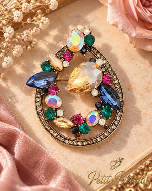 Multicolor crystal-look teardrop brooch on beige stone with blush satin and a pink rose