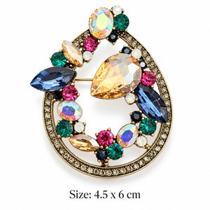 Vintage-inspired gold-tone teardrop brooch with champagne pear-cut center, blue marquise, green and pink crystal-look stones on white background, 4.5 × 6 cm