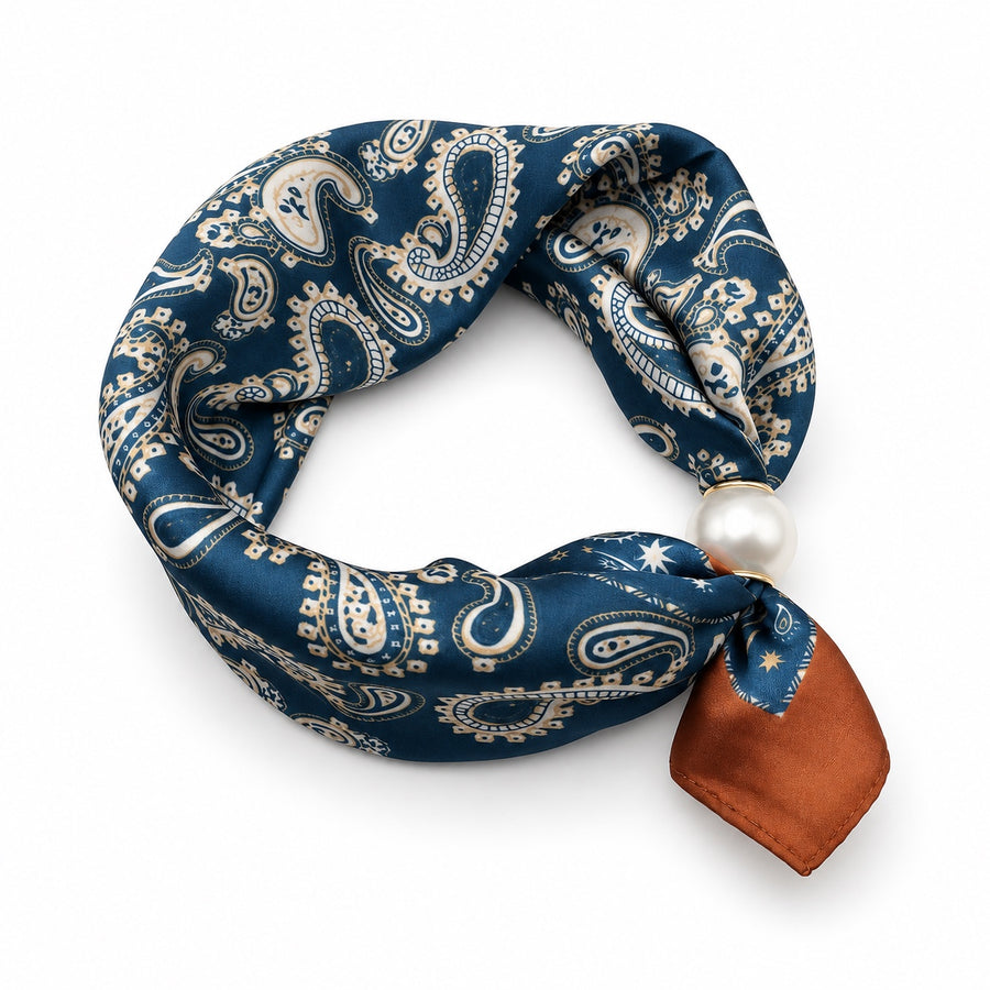 Navy blue paisley magnetic scarf with cream print, rust accent tail and pearl magnetic closure on white background