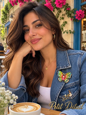 Woman wearing the rainbow enamel crystal butterfly brooch on her blue denim jacket at a cafe