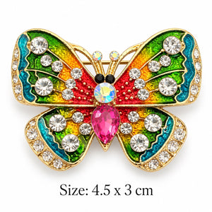 Rainbow enamel butterfly brooch with gold-tone edges, clear rhinestones and a pink teardrop-shaped centerpiece on white background, 4.5 × 3 cm
