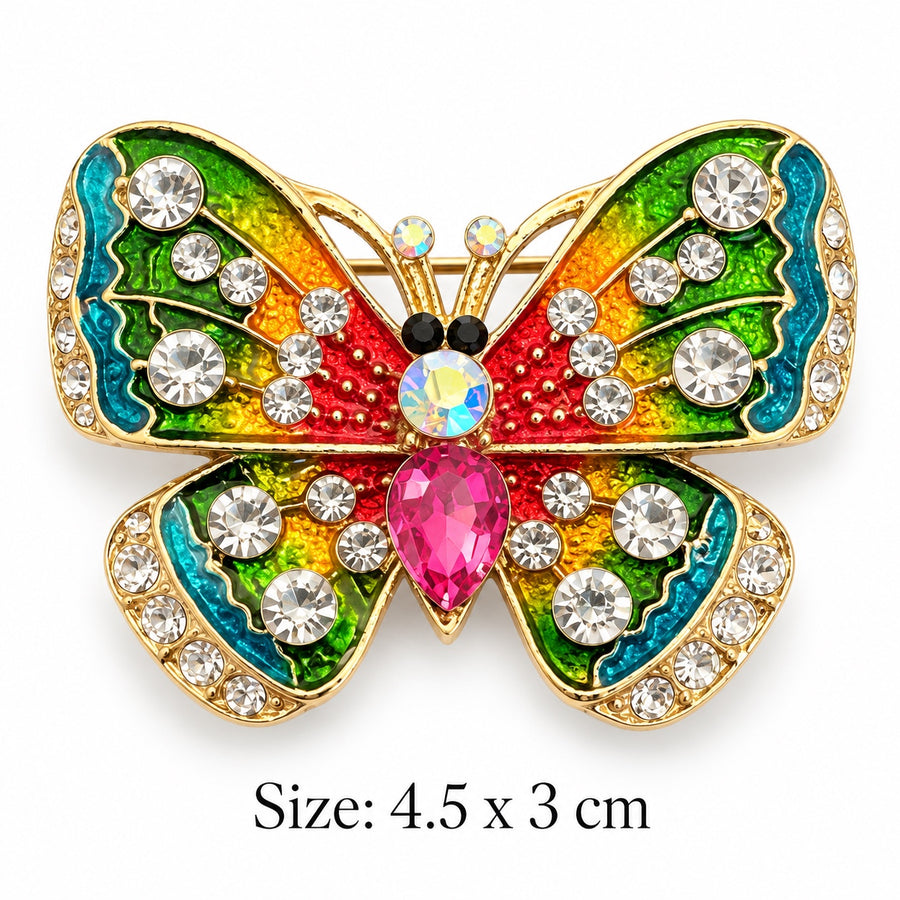 Rainbow enamel butterfly brooch with gold-tone edges, clear rhinestones and a pink teardrop-shaped centerpiece on white background, 4.5 × 3 cm