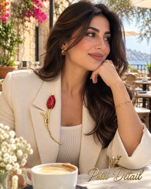 Woman wearing the red enamel long-stem tulip brooch on a cream blazer
