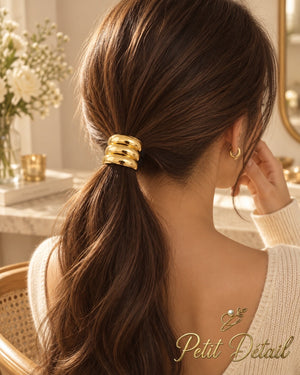 Woman wearing rounded triple-ridge gold-tone hair cuff on a low brown ponytail
