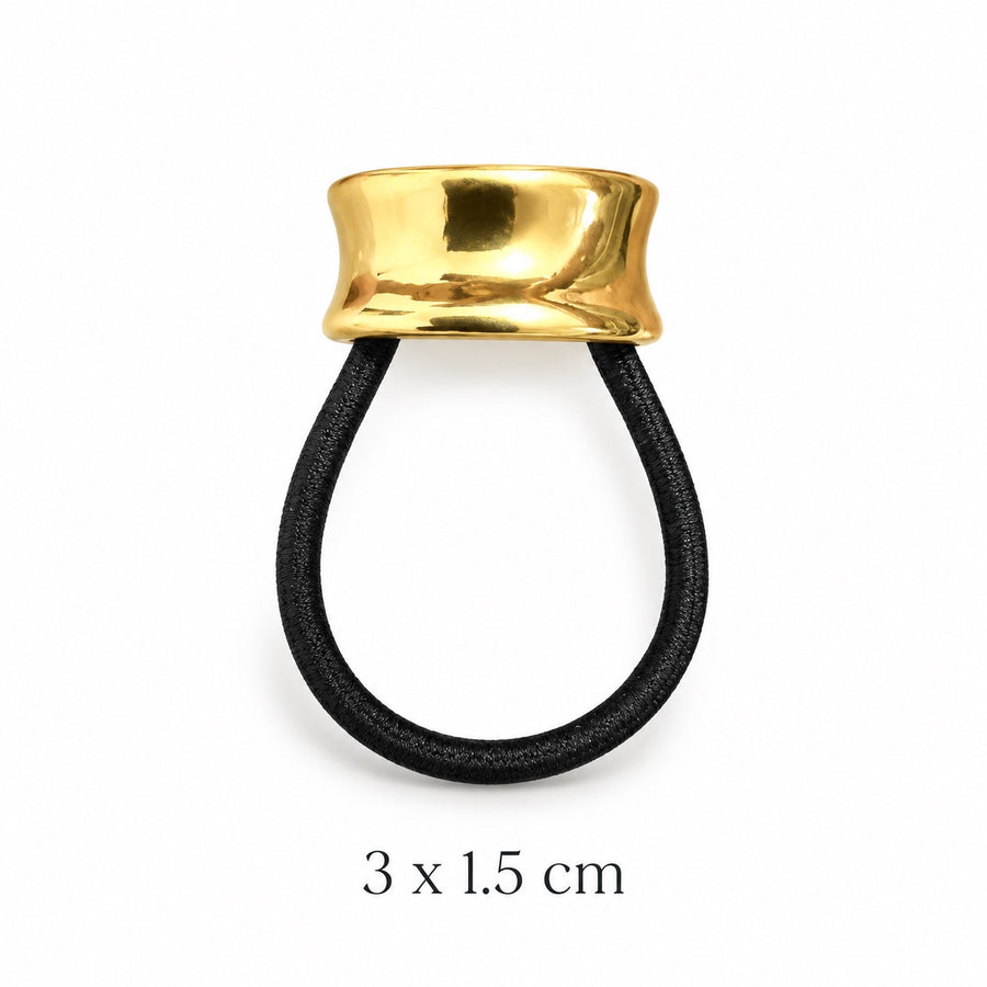 Small sculpted hourglass gold-tone hair cuff with black elastic on white background, 3 x 1.5 cm