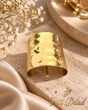 Polished gold-tone wave hair cuff on beige stone with satin and delicate flowers
