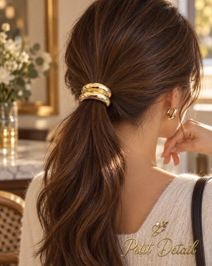 Woman wearing smooth gold-tone double-dome hair cuff over low brown ponytail